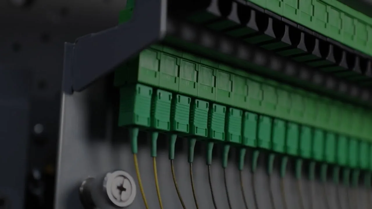 Close-up of green SC/APC fiber adapters in a Priority patch panel